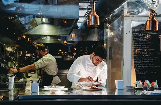 Chef plating food in a professional kitchen